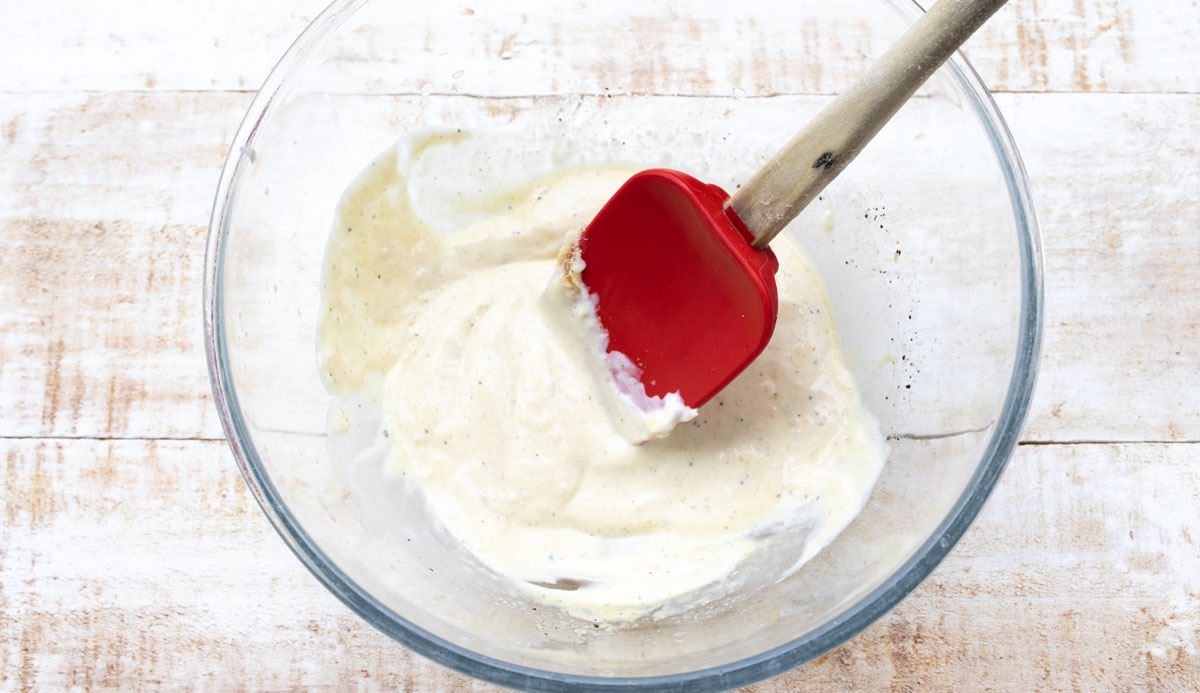 Mayonnaise in a bowl and a spatula.