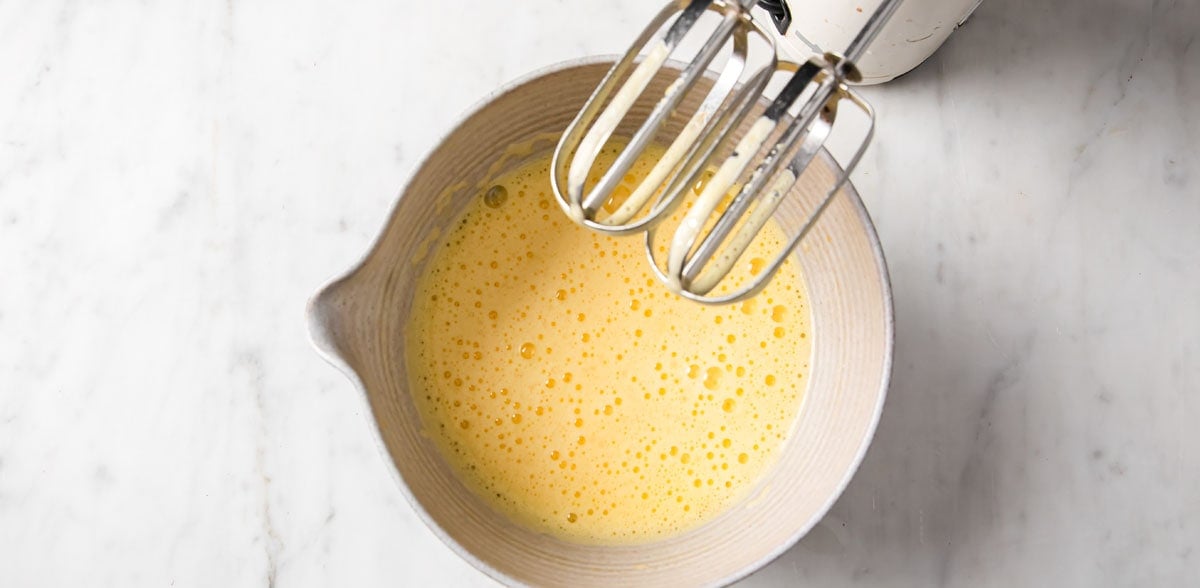 Whipping eggs with an electric mixer.