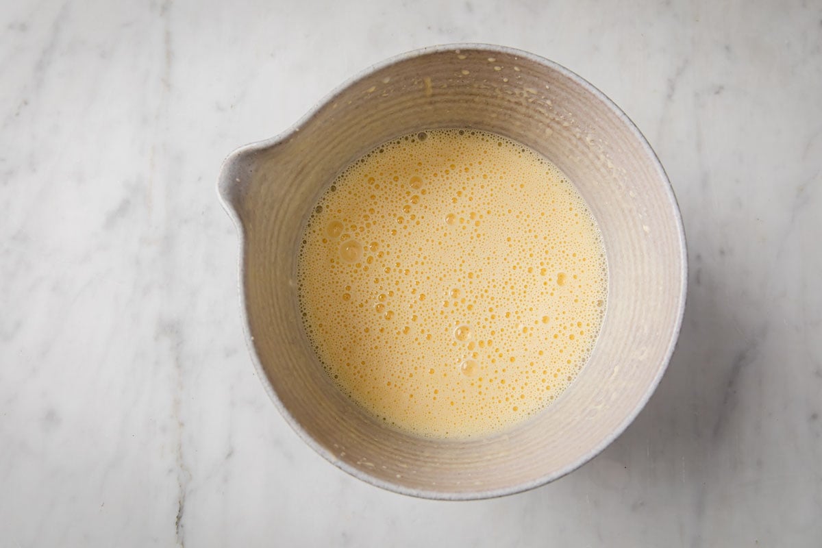 Whipped egg and other wet ingredients mixed in a bowl.