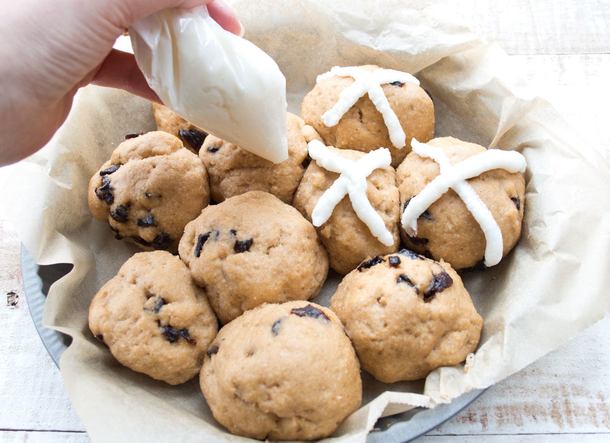 Piping the crosses on the buns.