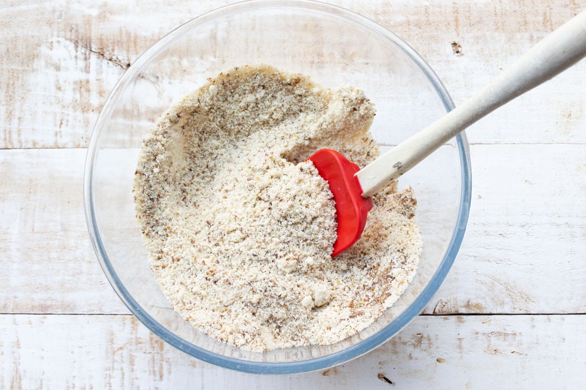 Mixing dry ingredients in a bowl with a spatula.