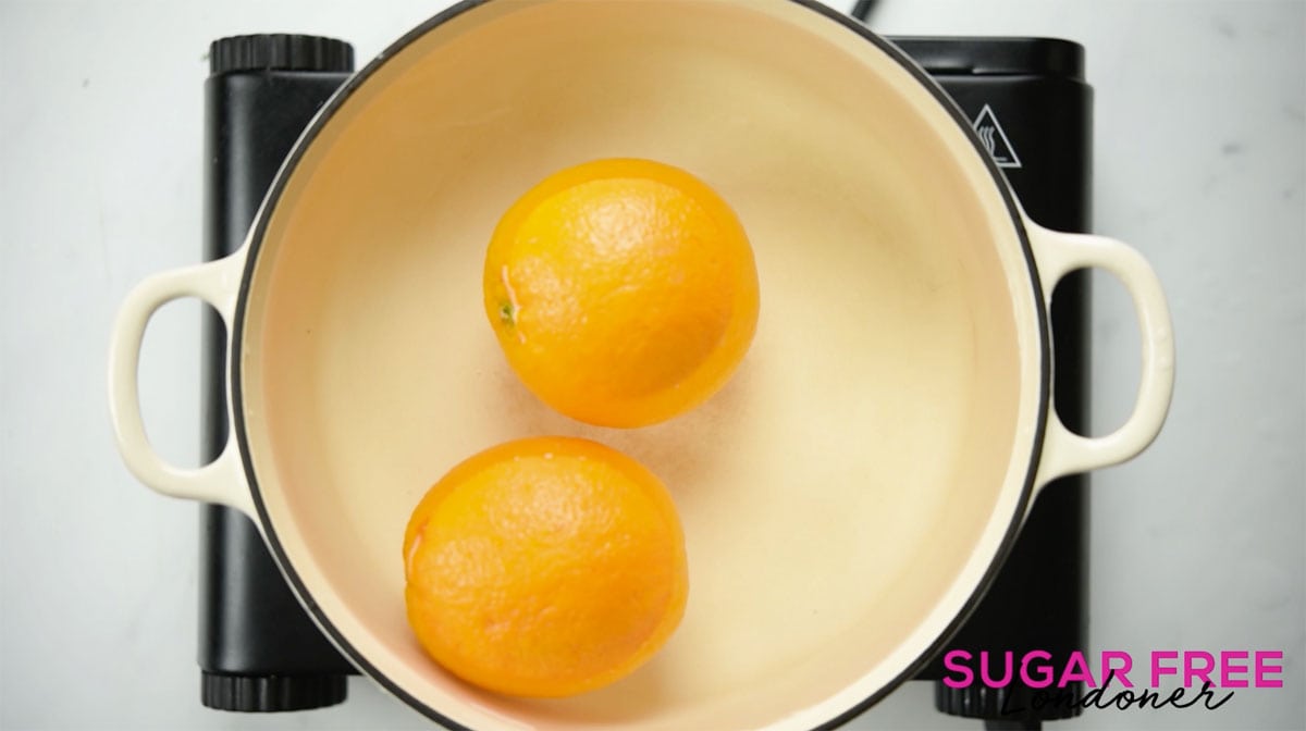 2 oranges in a pan with water.