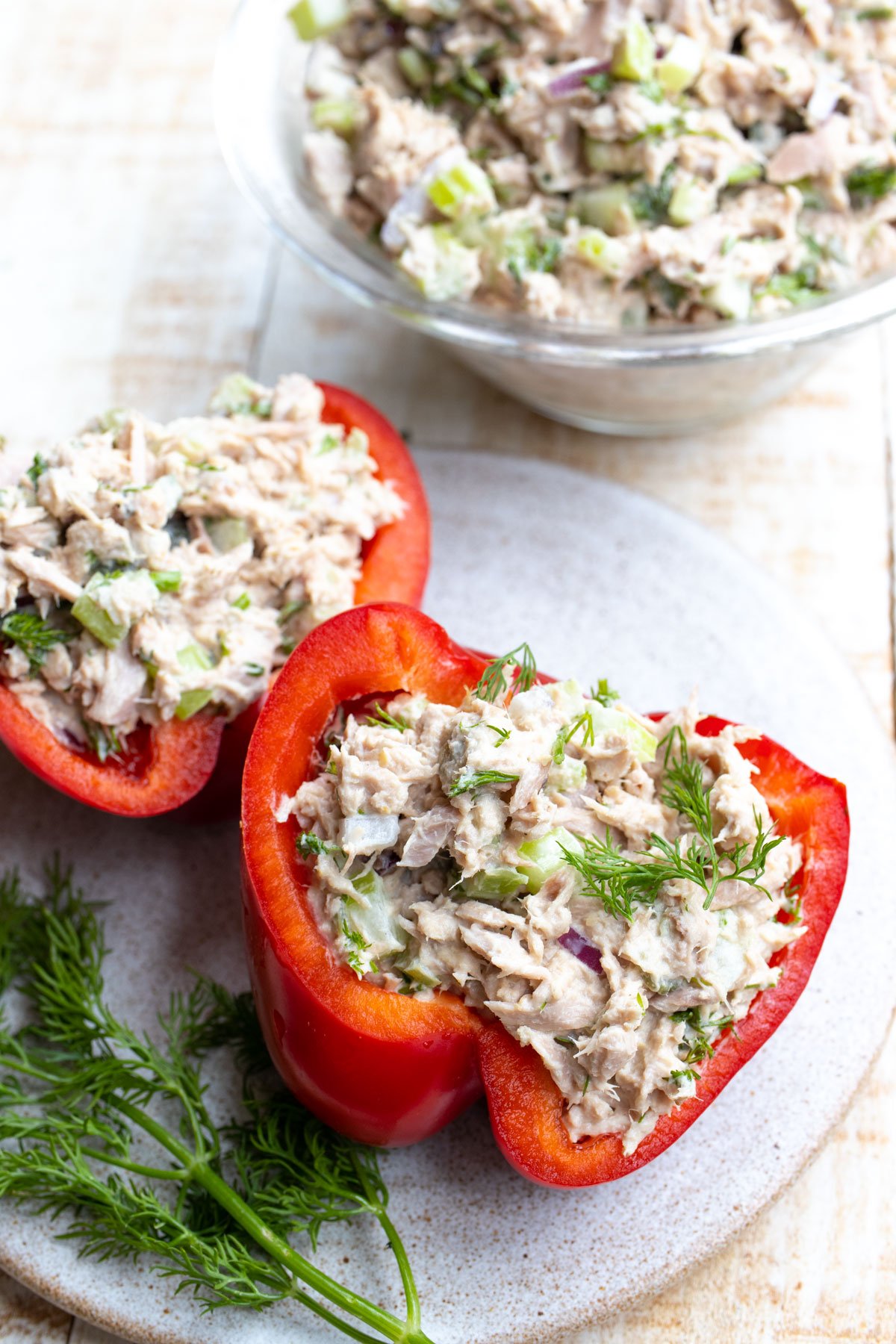 Halved bell peppers filled with tuna salad on a plate.