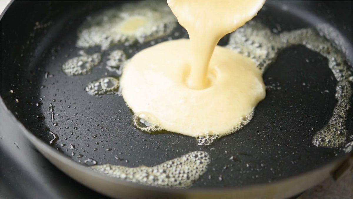 Pouring the batter into a hot frying pan.