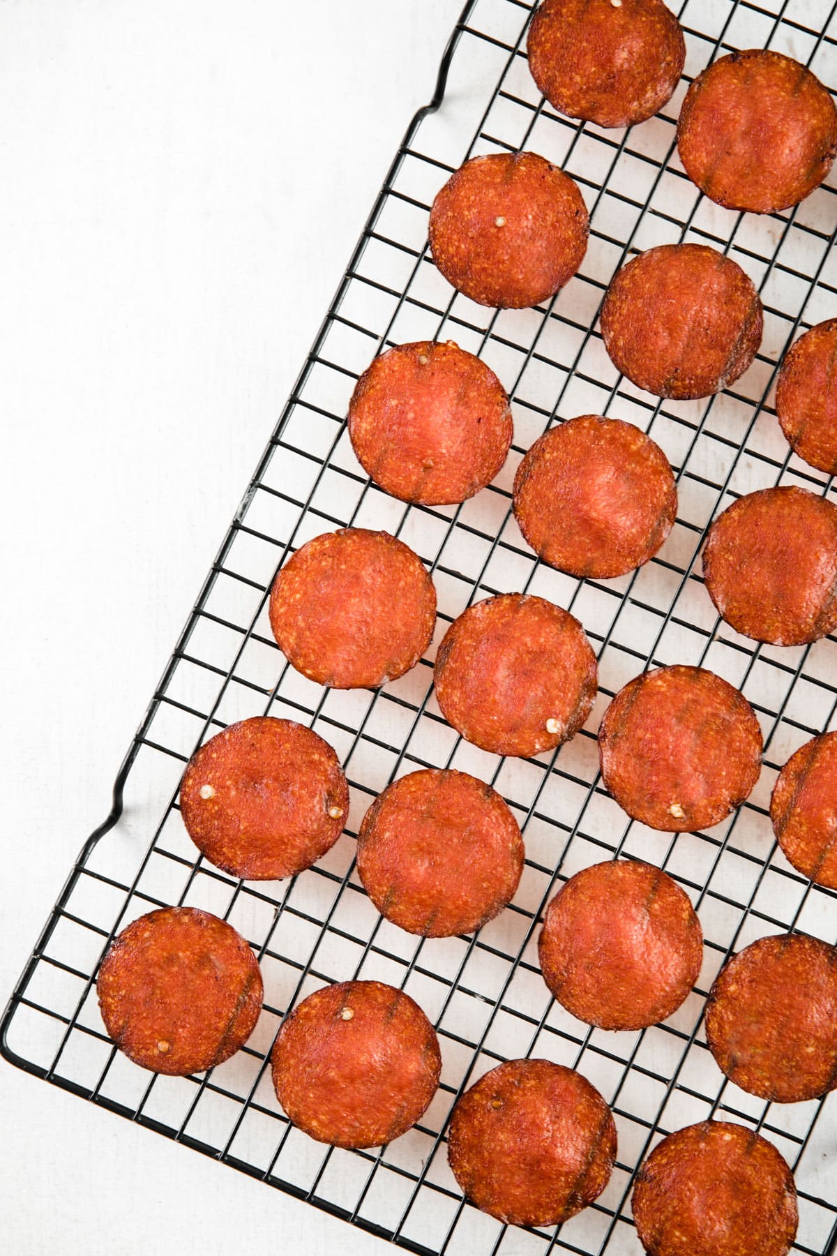 Pepperoni chips on a wire rack.