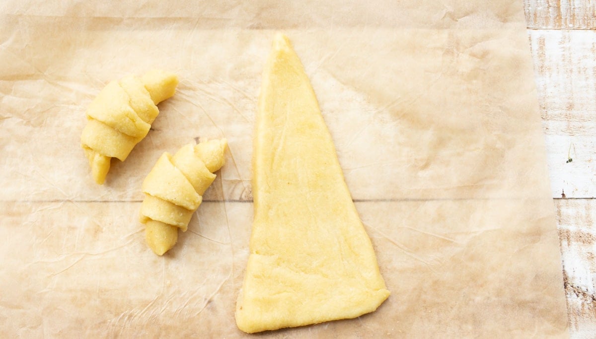 A dough triangle and two rolled up triangles.