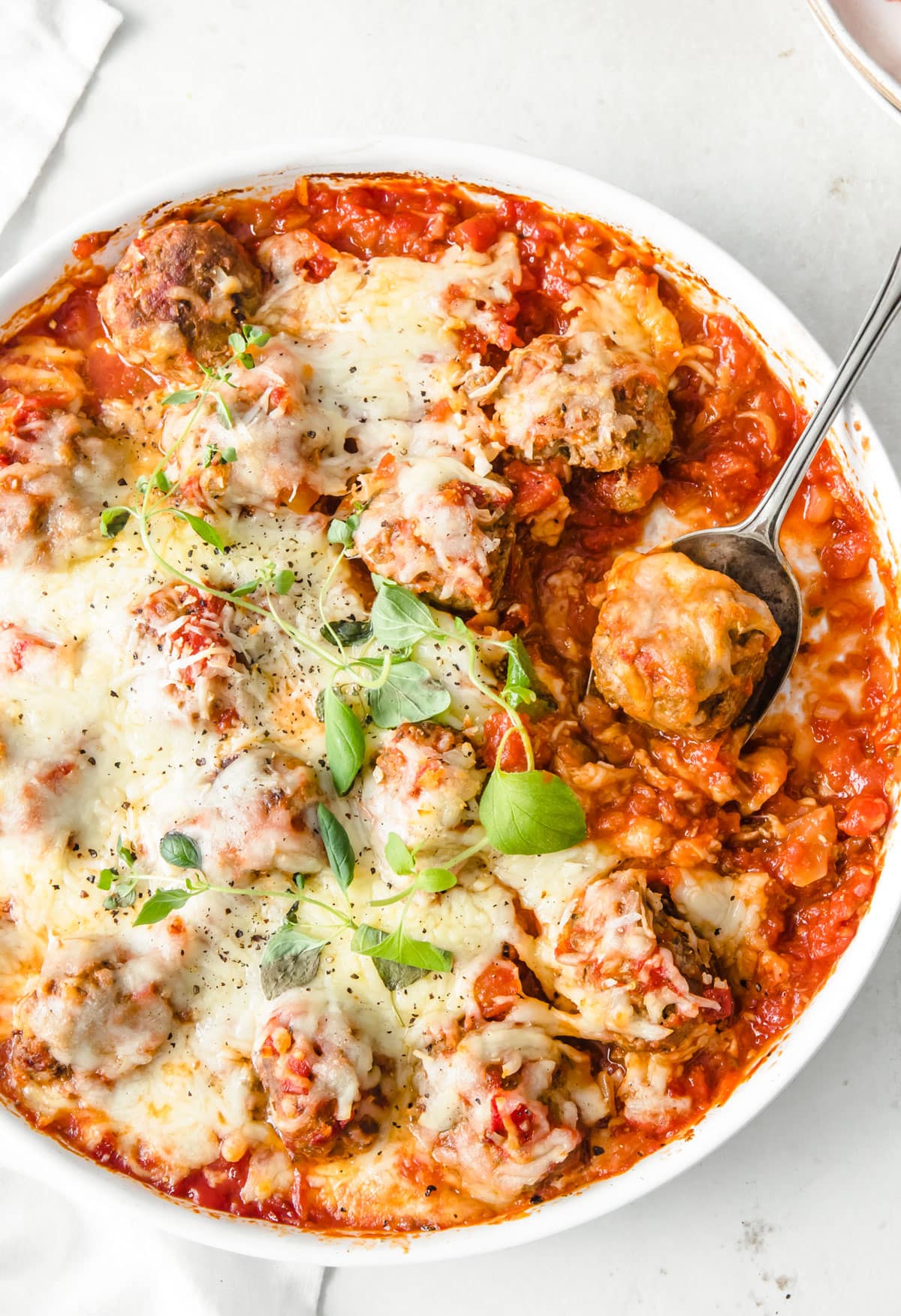 Baked meatballs in tomato sauce topped with melted cheese.