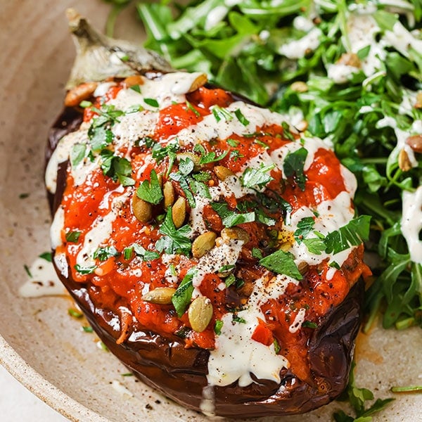 Roasted stuffed aubergine with a green side salad.