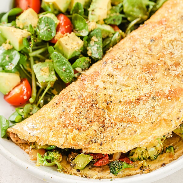 A vegetable filled omelette with salad.