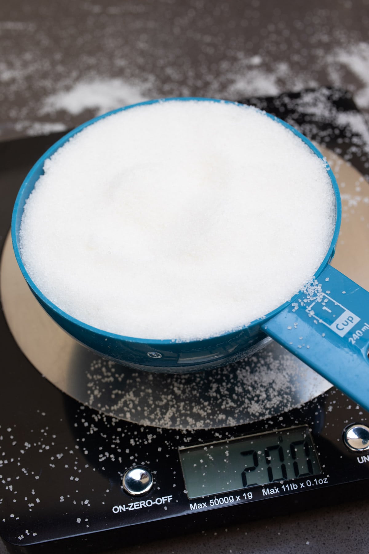 Sweetener or sugar in a measuring cup on digital scales.