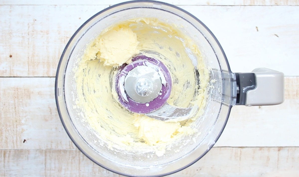 Blended butter and sweetener in a food processor bowl.