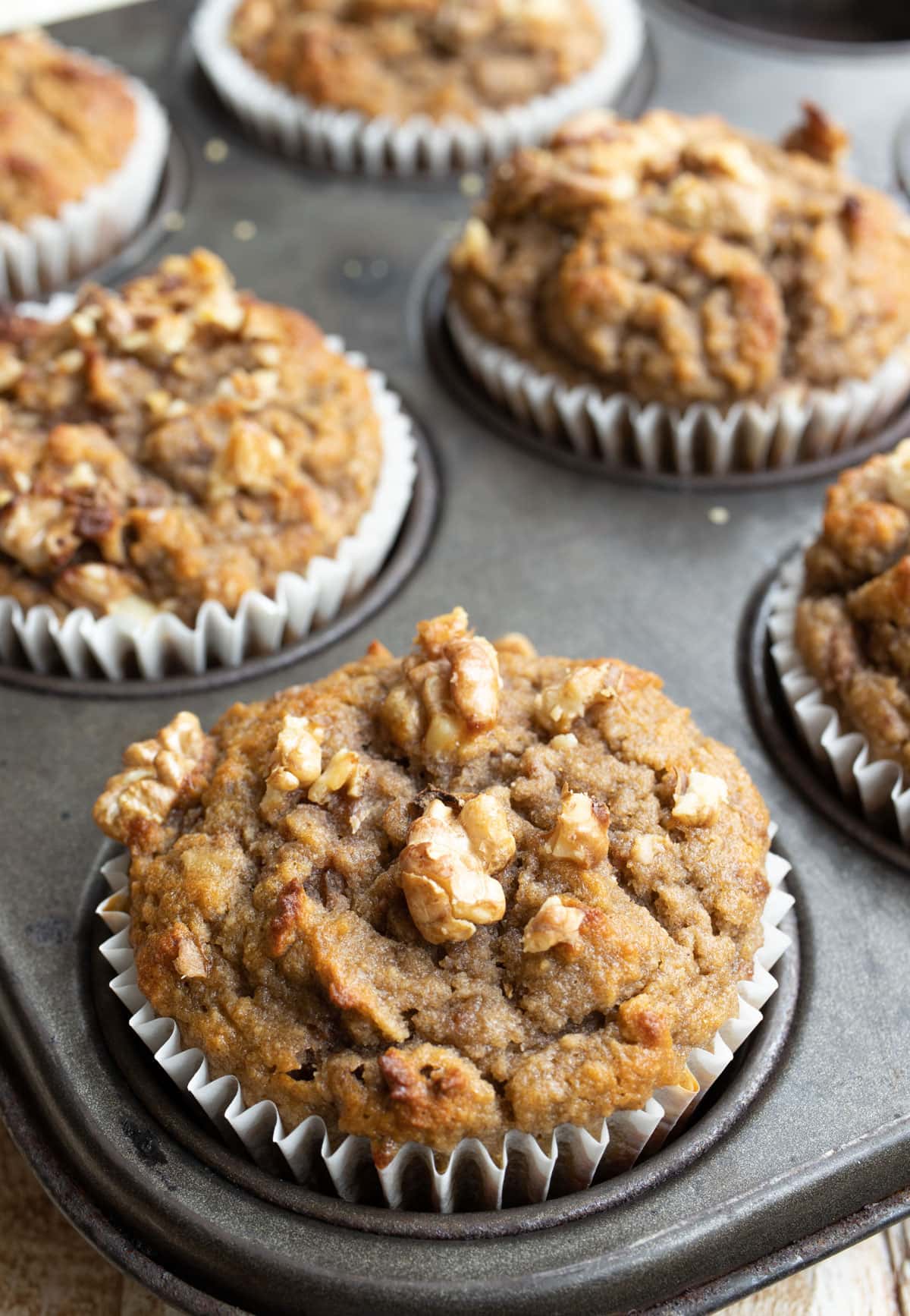 Banana muffins topped with chopped walnuts.