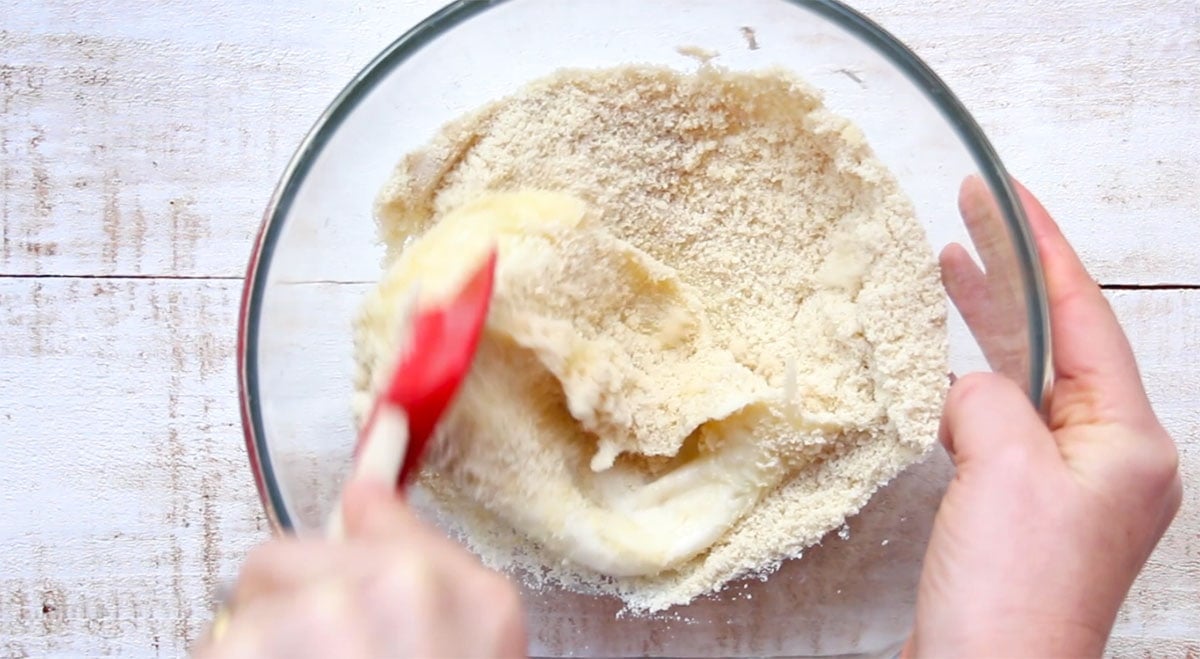 Stirring the dough with a spatula in a bowl.