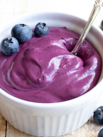 A bowl with blueberry cream cheese topped with blueberries.