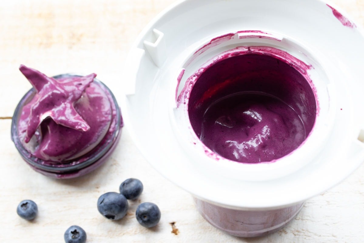Blended blueberries and cream cheese in a food processor bowl.