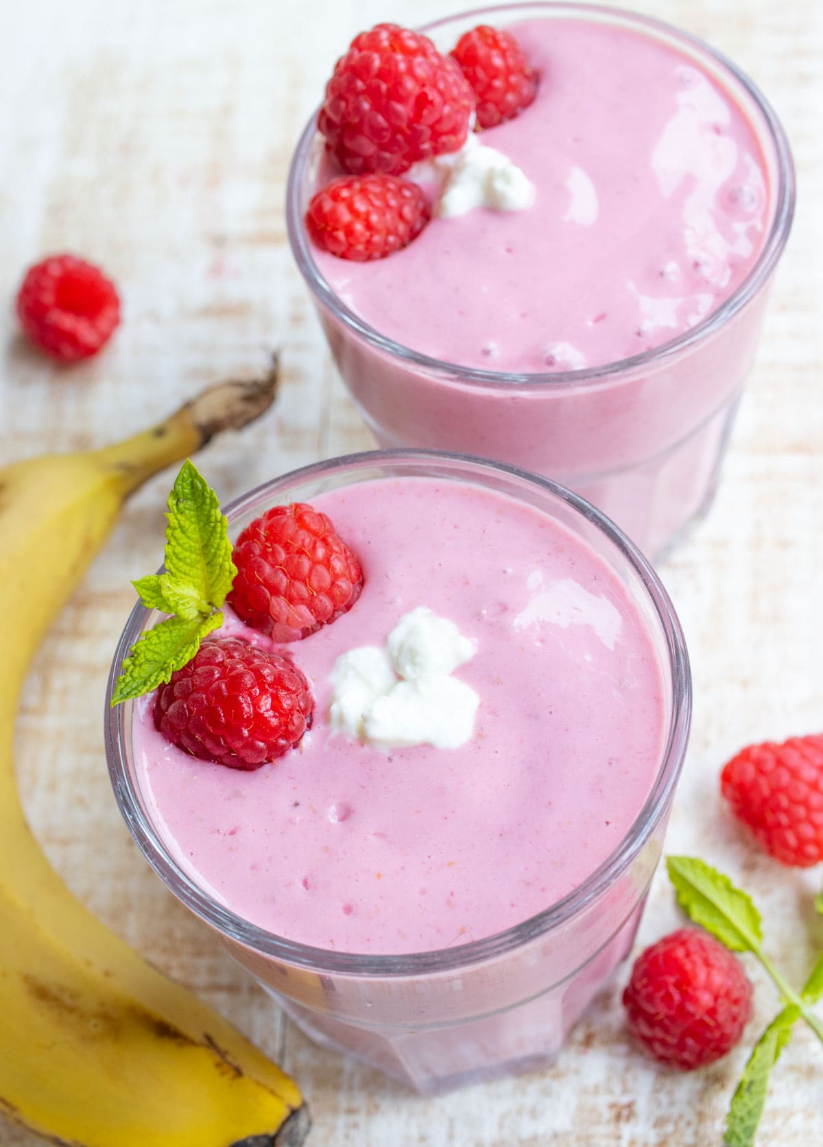 Two glasses with cottage cheese smoothie and a banana.