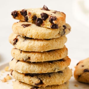 A stack of keto chocolate chip cookies topped with half a cookie.