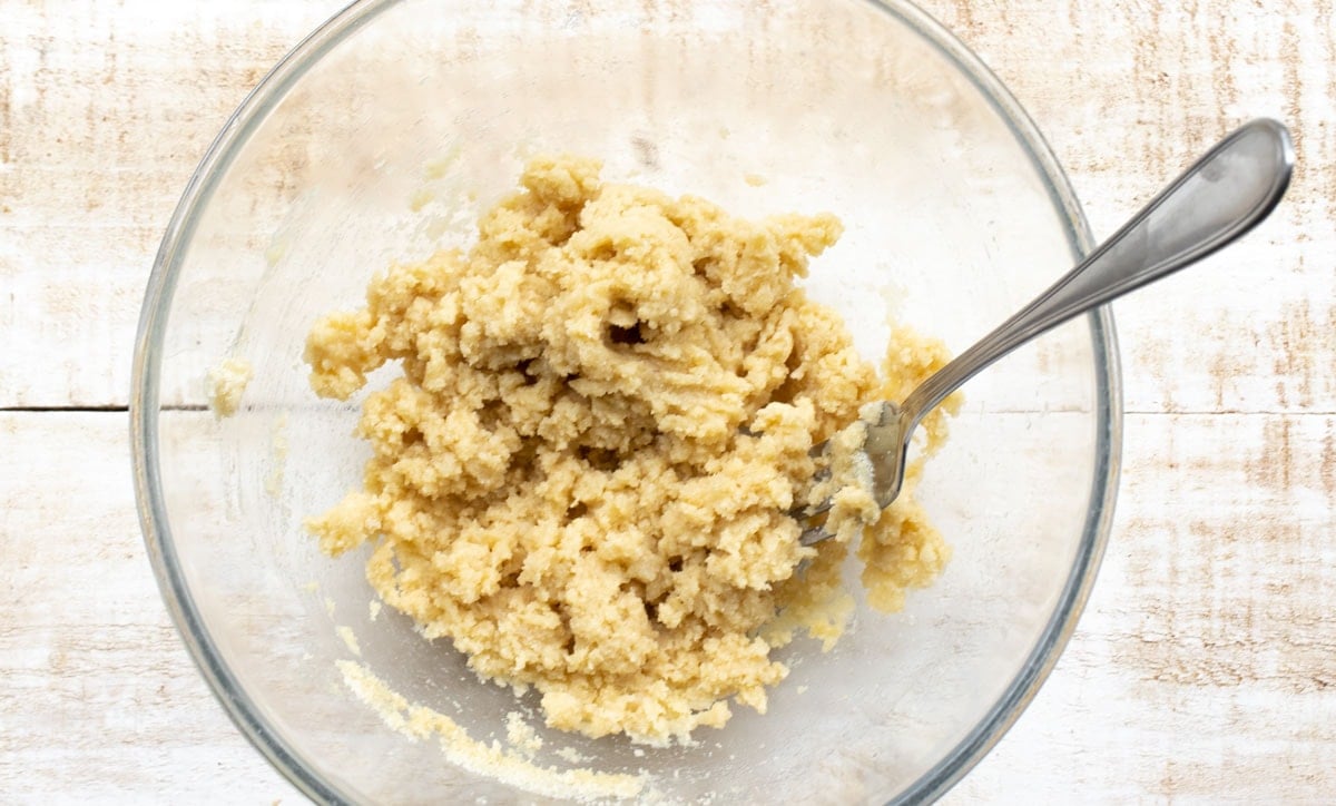 Cookie dough in a glass bowl and a fork.