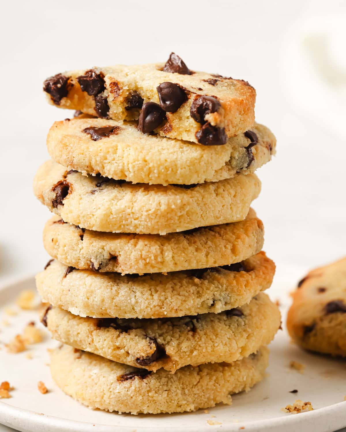 A stack of low carb chocolate chip cookies with half a cookie sitting on the top.