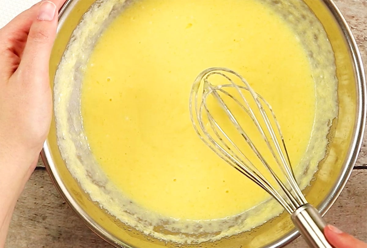 Mixing wet ingredients in a bowl with a ballon whisk.