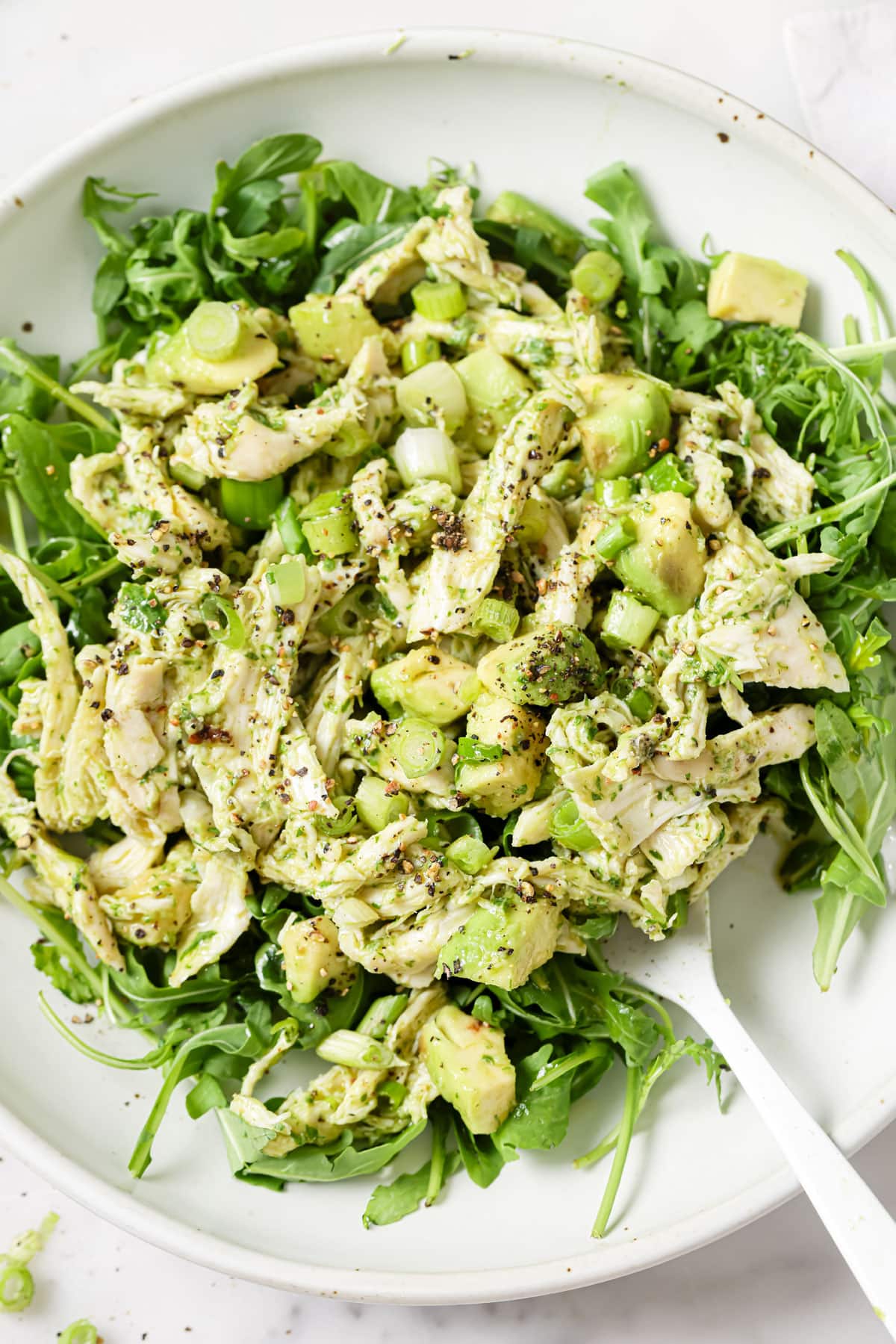 Avocado chicken salad on a bed of rocket salad.