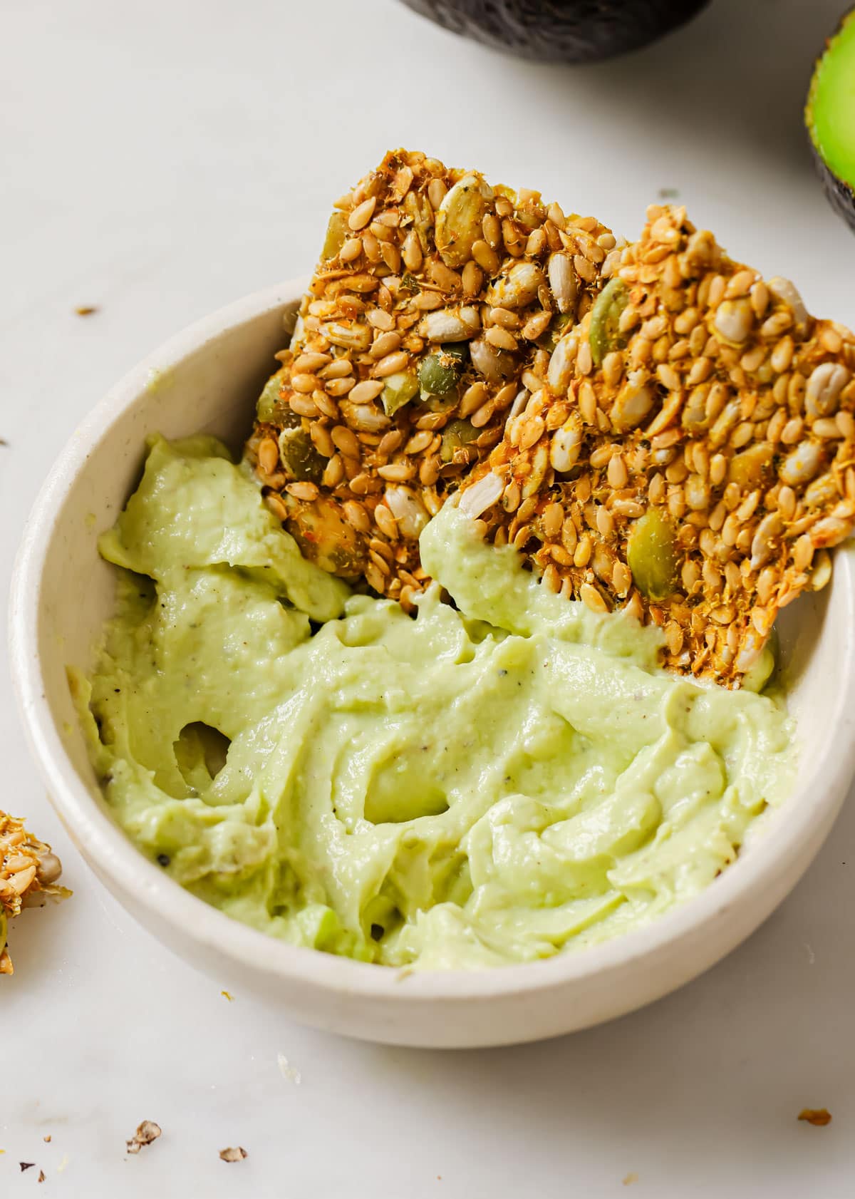 Seeded crackers with avocado spread.