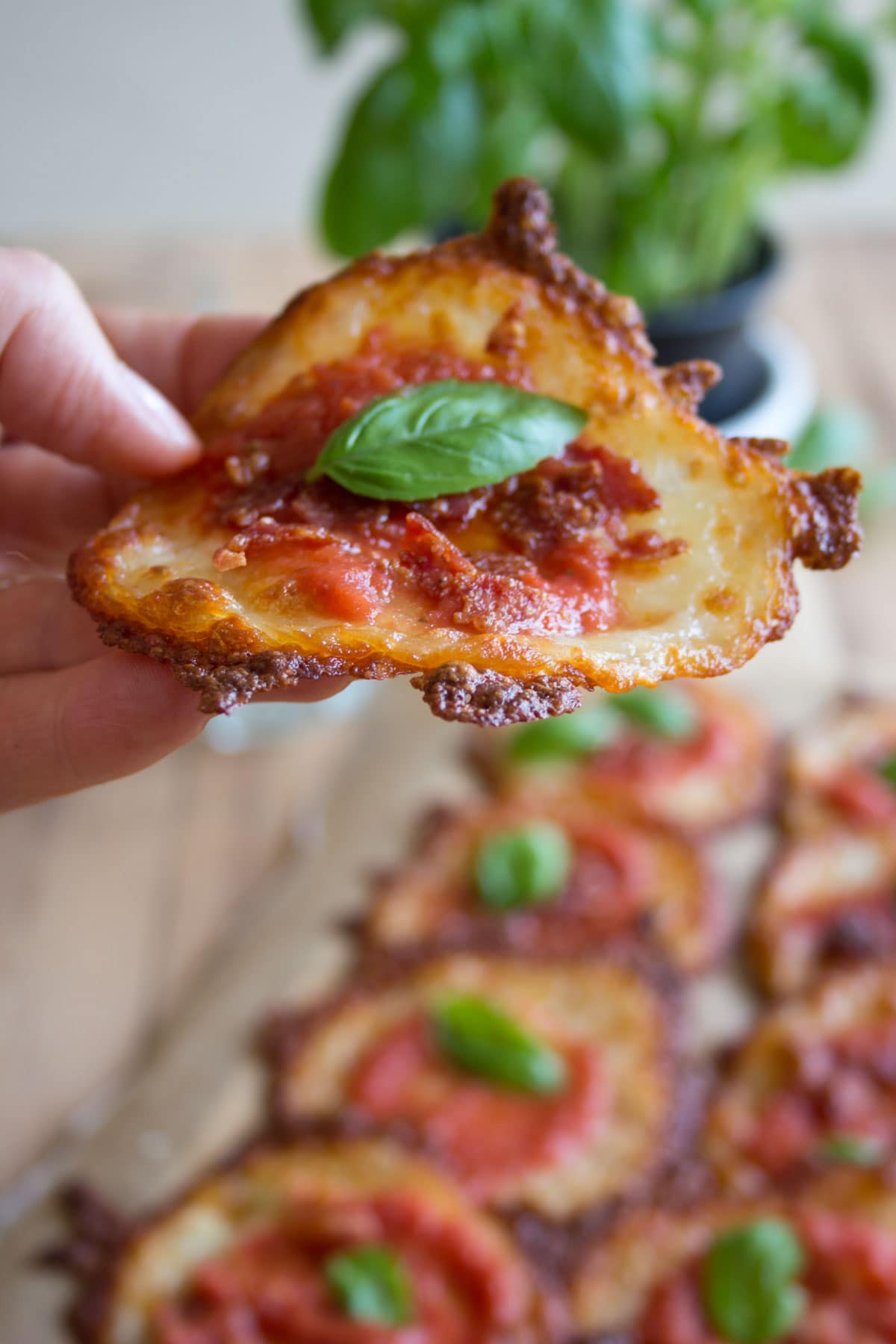 Hand holding a keto mini pizza.