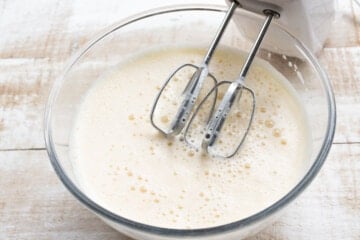 Blended wet ingredients in a bowl and an electric mixer.
