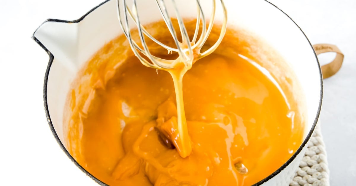 Caramel in a pan with a balloon whisk.