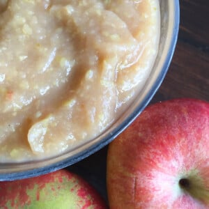 Sugar free applesauce in a bowl and apples.