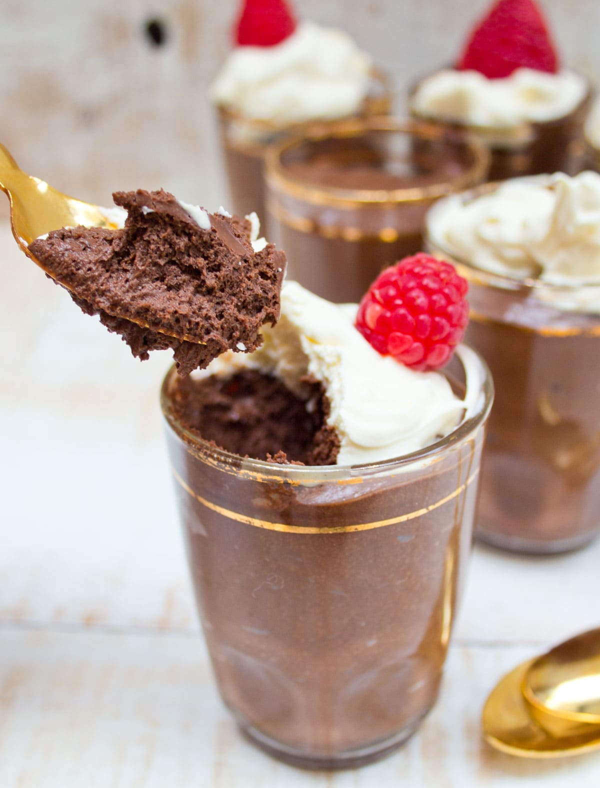 Taking a spoon of chocolate mousse out of a dessert cup.
