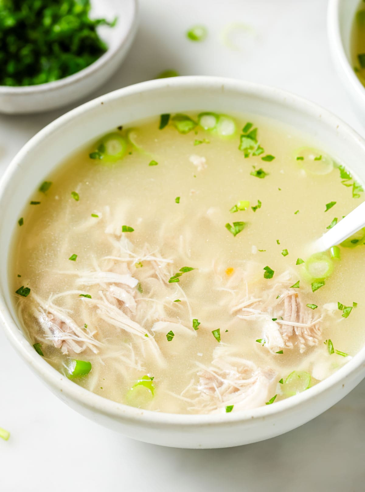 Clear chicken soup in a bowl.