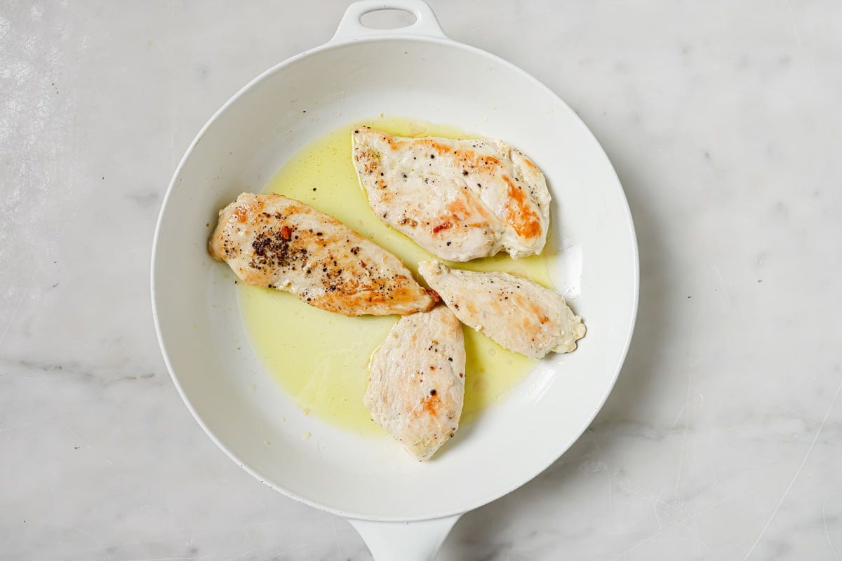 Fried chicken fillets in a pan.