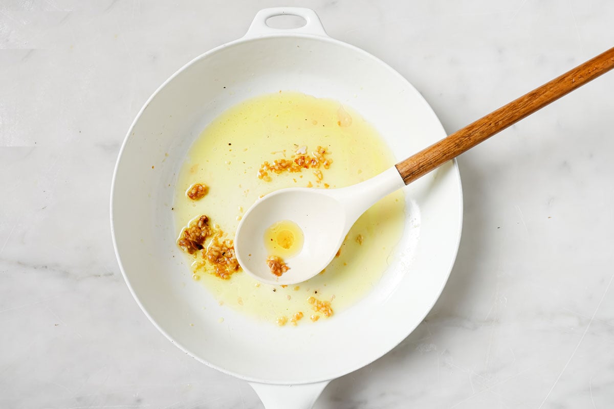 Browned garlic in a pan and a spatula.