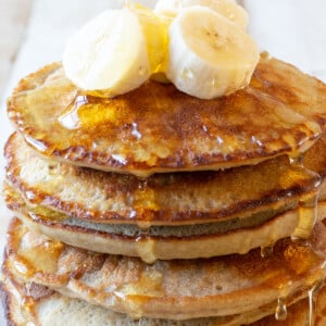 A stack of almond flour banana pancakes with syrup.