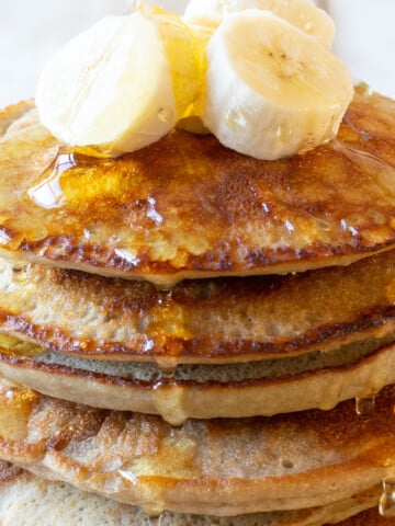 A stack of almond flour banana pancakes with syrup.
