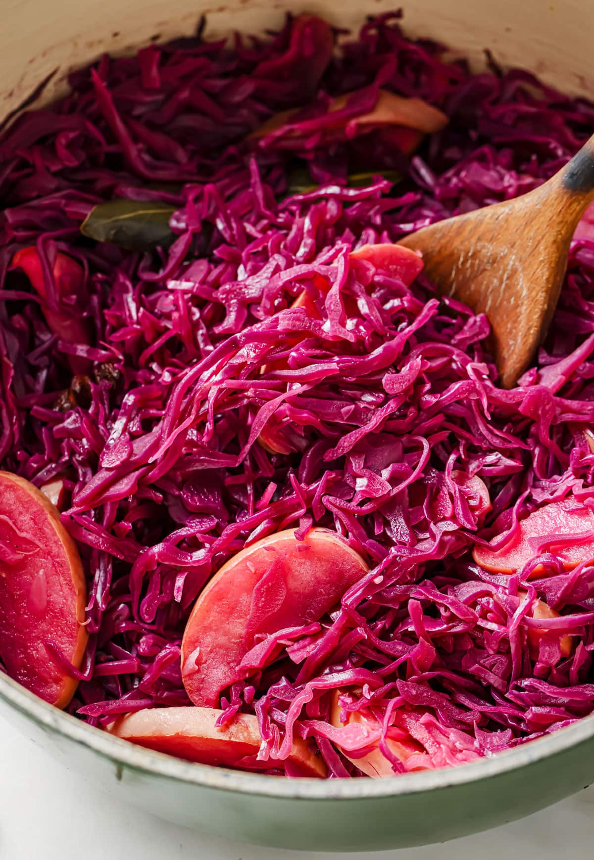 Cooked red cabbage with apples in a saucepan.