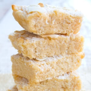 A stack of coconut flour blondies topped with desiccated coconut.