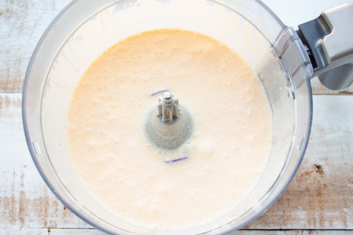 Whisked egg mixture in a food processor bowl.