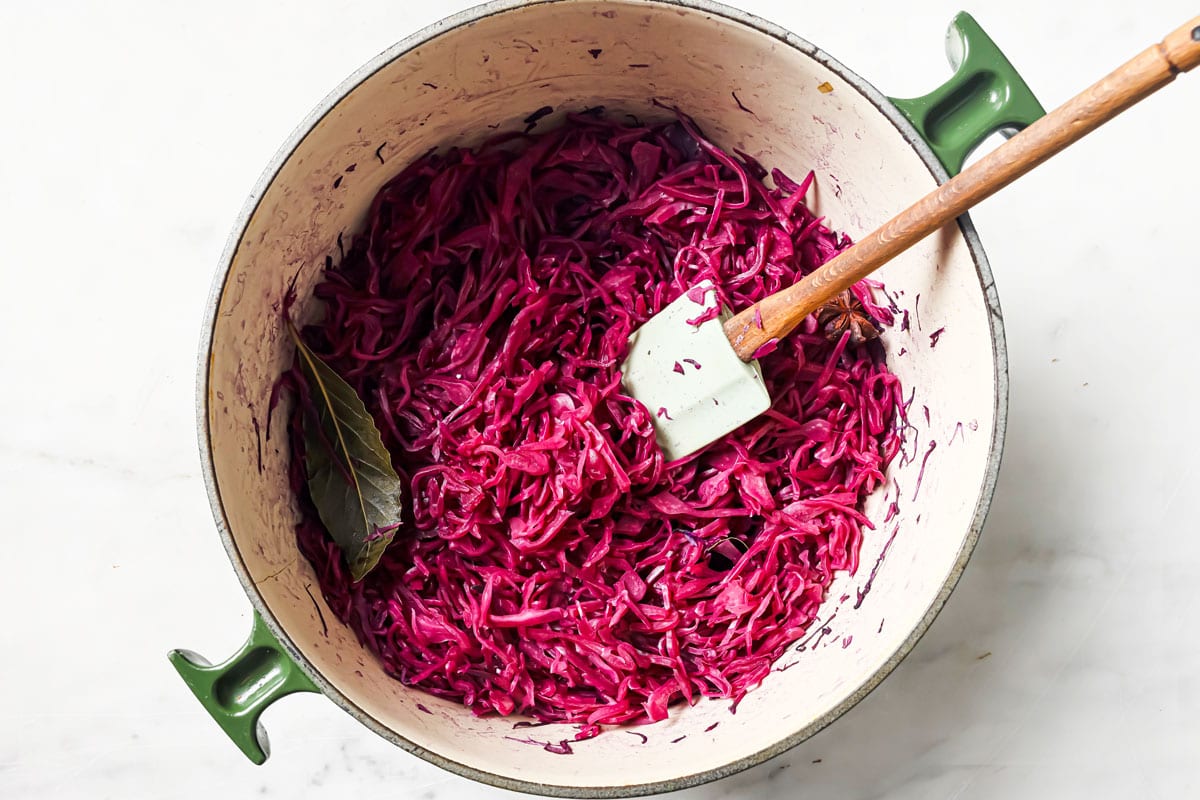 Cooked red cabbage in a pot with a bay leaf.