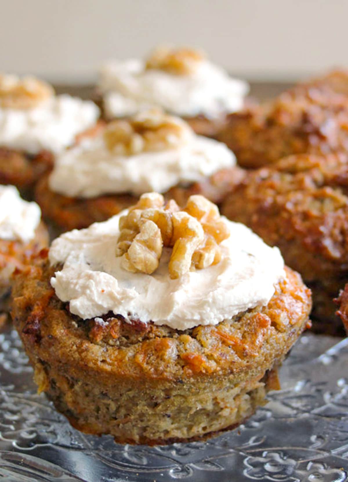 A sugar free carrot cake muffin topped with cream cheese frosting.