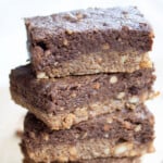 A stack of homemade peanut butter protein bars with a peanut butter and a chocolate layer.