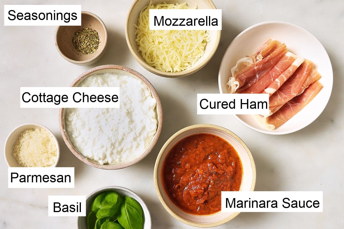 Ingredients to make this pizza bowl recipe, measured into bowls and labelled.