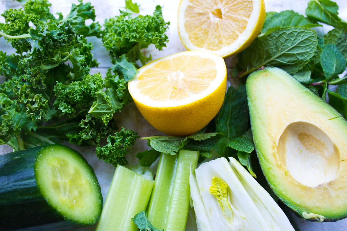 Kale, lemon, avocado and other ingredients to make a green smoothie.
