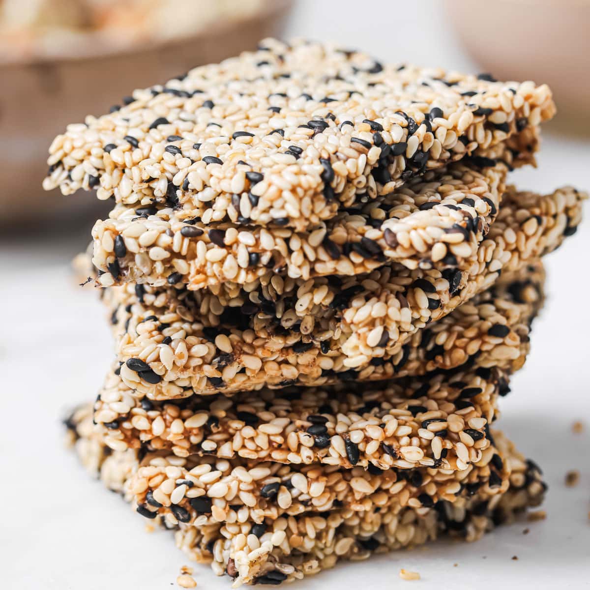 A stack of sesame crackers made with black and white sesame seeds.