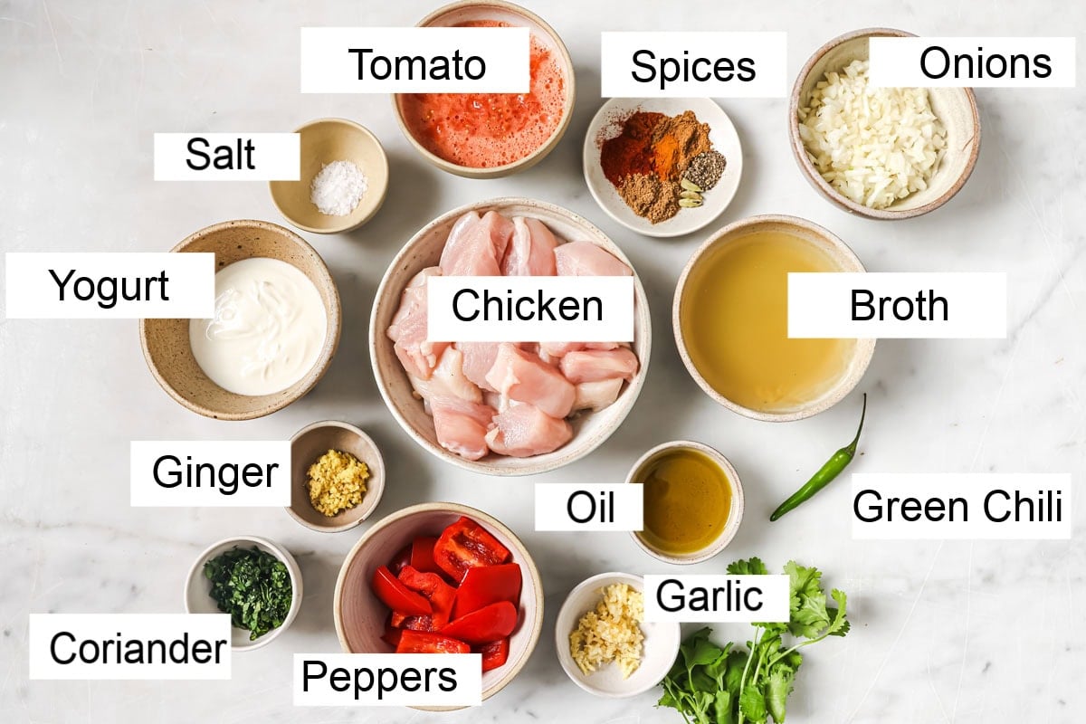 Ingredients to make chicken curry, labelled and measured into bowls.