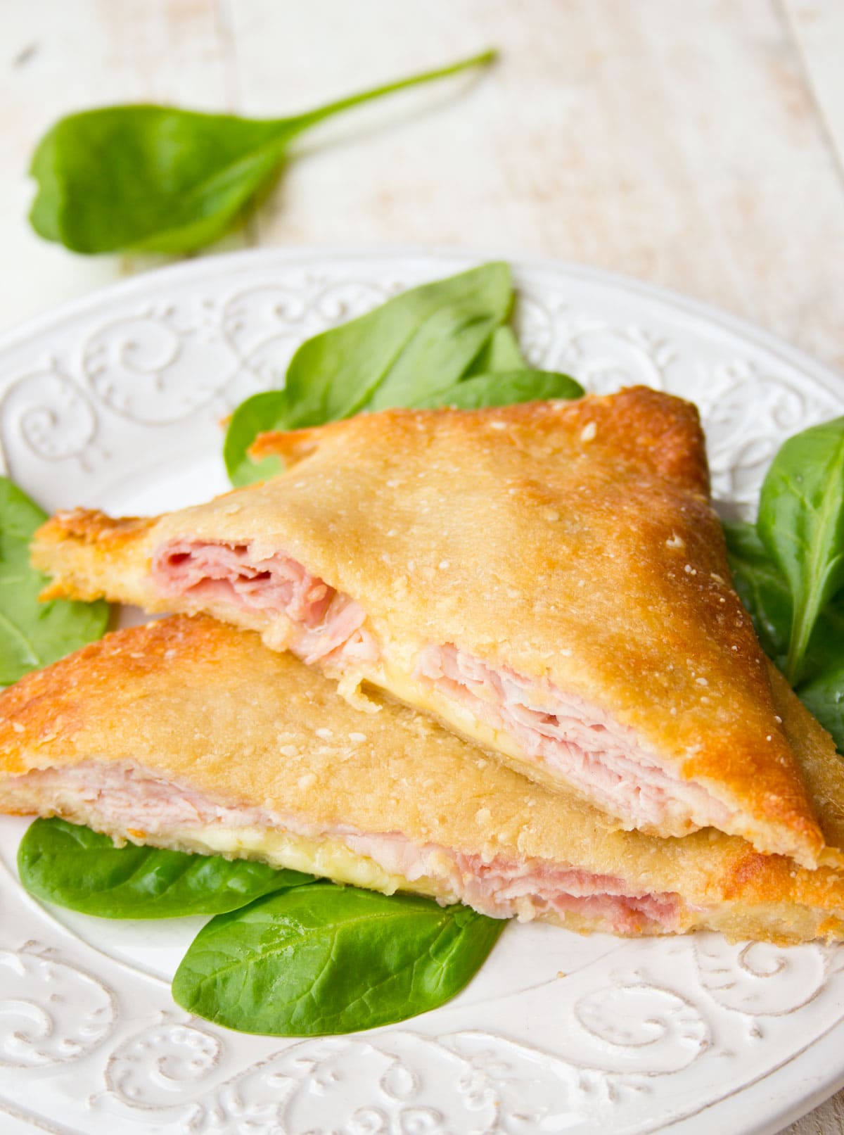 A keto croque monsieur sliced diagonally and filled with ham and cheese.