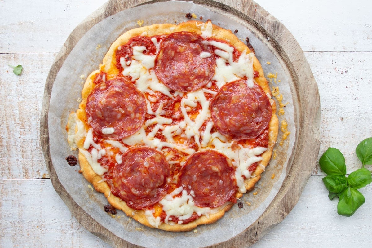 Baked low carb pizza with a salami and mozzarella topping.