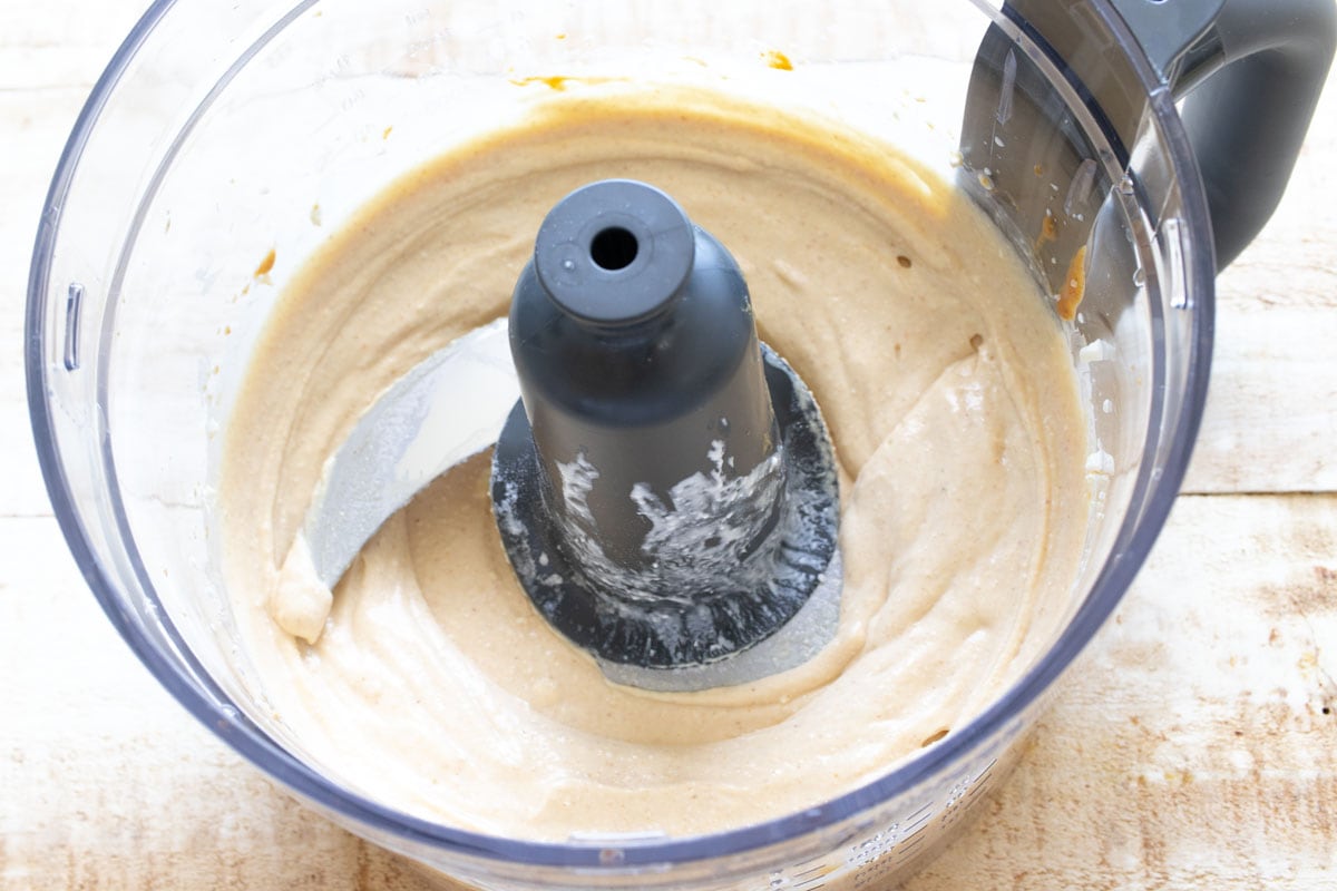 The blended peanut butter cottage cheese mixture in a food processor bowl.