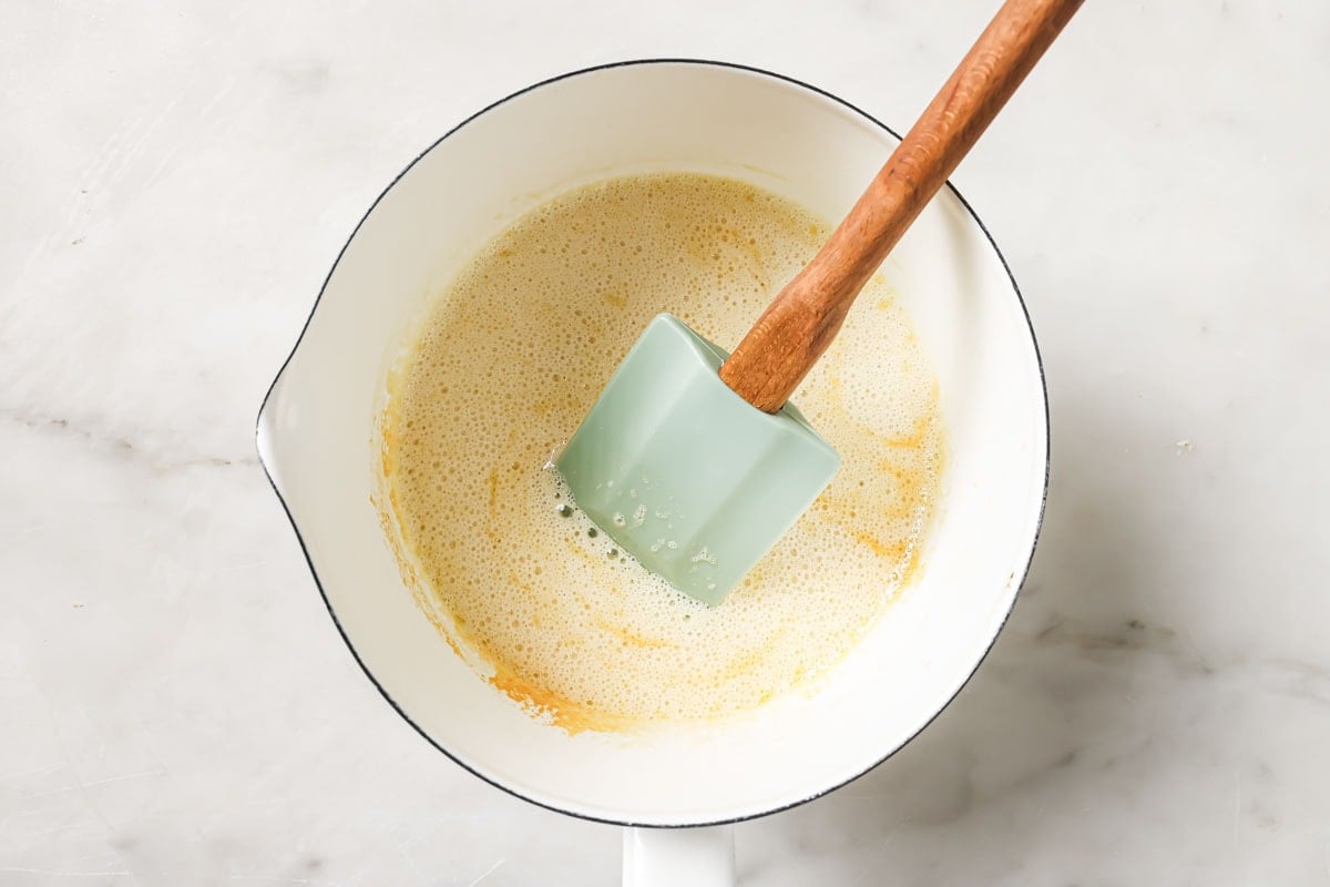 Melted butter in a saucepan with baking soda creating fizz.